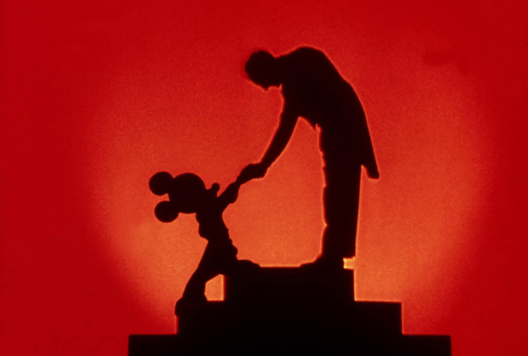 Ujęcie z "Fantazji" Walta Disneya, 1940. Myszka Miki i Leopold Stokowski podają sobie dłonie, fot. Everett Collection / East News